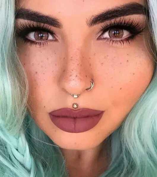 Double nostril piercing with a medusa piercing and hoops