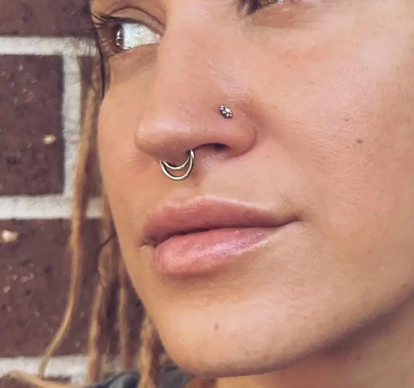 Double nostril piercing with stacked jewelry